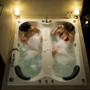 A couple enjoying a relaxing soak in their two person whirlpool bathtub.