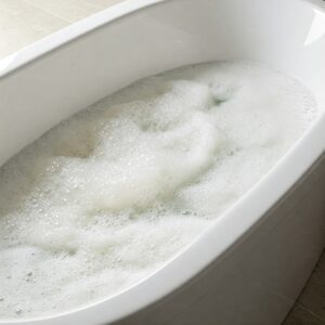 Relaxing view from above of a slipper bathtub filled with foamy bubbles.