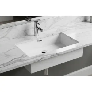 A contemporary rectangular example of under counter bathroom sinks, mounted beneath a marble countertop.