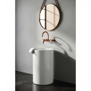 A space-saving wall-mounted copper bathroom faucets installed above a freestanding basin.