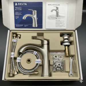 The complete packaging of the Delta Trinsic bathroom faucet, including the matching pop-up drain assembly.